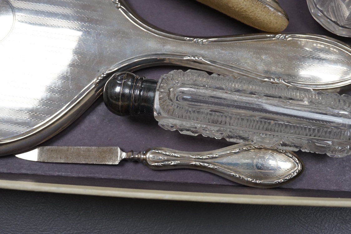 Two silver mounted hand mirrors including Reynold's Angels, Chester, 1899, 26.7cm, together with four silver mounted dressing table implements, a pair of silver mounted dwarf candlesticks and four assorted silver mounted